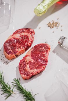 Raw beef on a cutting board  with spices and ingredients for cooking.