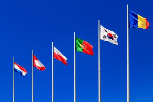 International flags against a blue sky - Portugal, Tchad, Netherlands, Poland, Korea