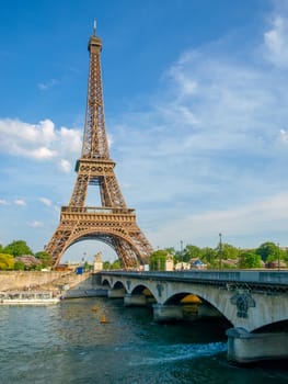 Eiffel Tower with bridge over river Seine on the foreground in springtime in Paris, France.
