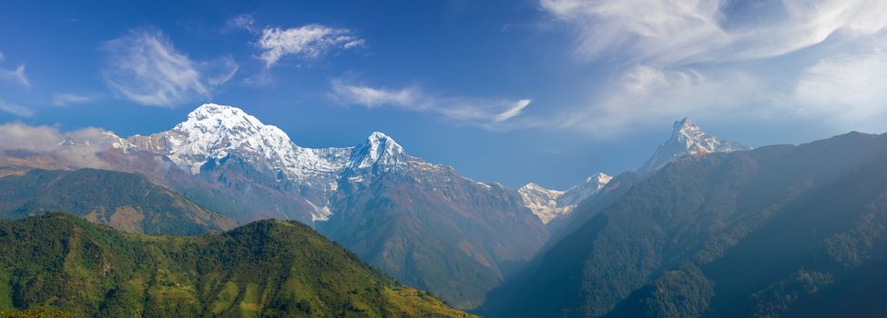 Panorama of the south face of the Annapurna South peak, Hiunchuli peak, Modi Khola valley and Fishtail Mountain on the background of sky with clouds in morning in the Himalayas
