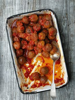 close up of rustic italian meatball in tomato sauce