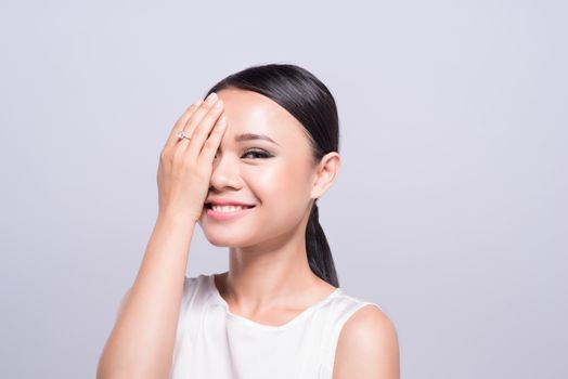 Beauty concept. Beautiful Asian woman face on grey background