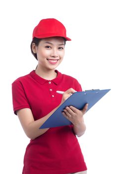 Beautiful young delivery woman in red t-shirt and cap smiling, holding a folder and making notes, on white background