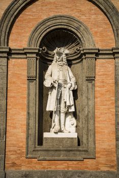 Statue of king Charles III in a niche of the wall of the Royal Palace of Naples, Italy