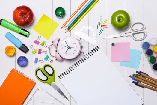 School stationery or office supplies on wood background.