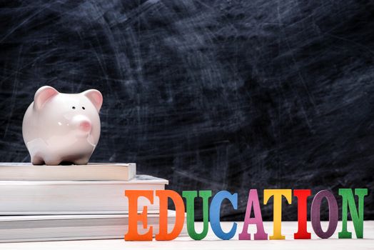 Education financial saving. Pink Piggy bank on top of books with chalkboard.