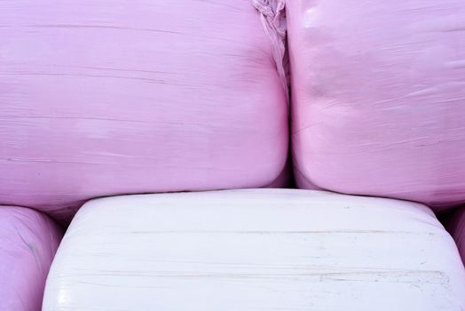 Bales of hay in pink and plastic wrapping.