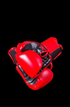 Red boxing gloves on a black background.