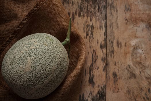 Melon on old sackcloth and wood floor.