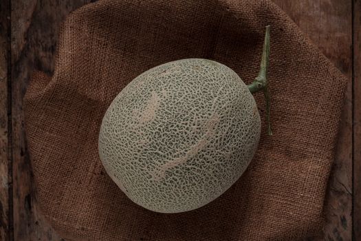 Melon and sackcloth on the old wooden floor.