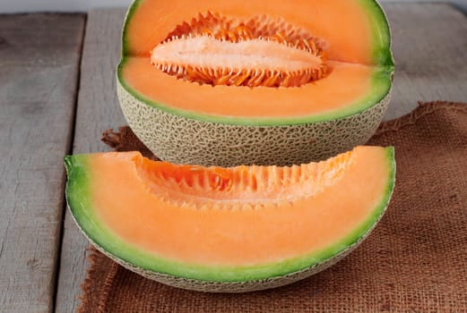 Melon sliced on old sackcloth and wood floor.