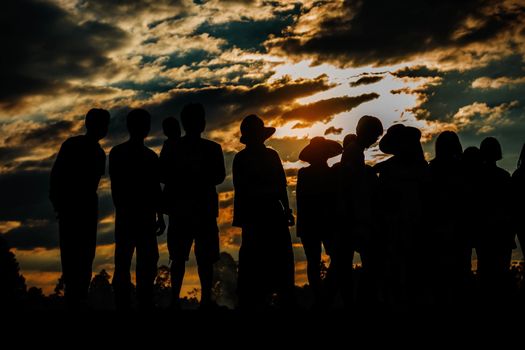 group of people in fields at the sunset.