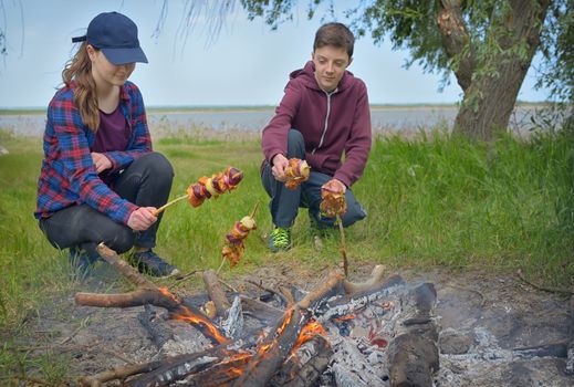 Teenagers enjoying together barbecue outdoors 