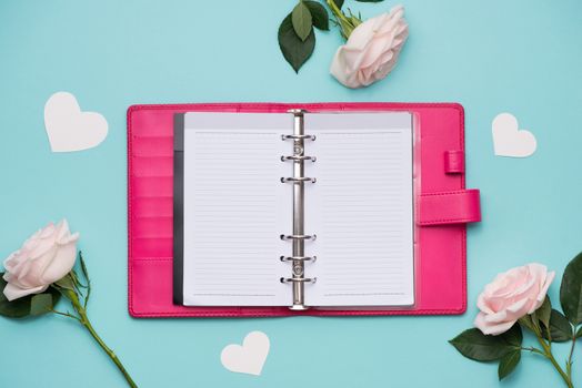 Mother's Day concept. Pink roses with gift box. Open notebook for copy space.