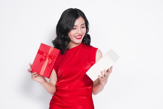 Pretty young asian woman dressed in red dress with a present