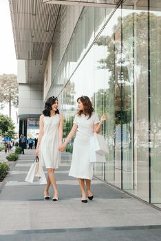 Beautiful asian girls with shopping bags walking on street at the mall