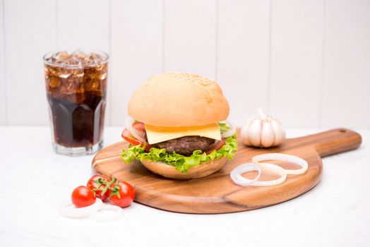 Homemade BBQ burger with coke on wooden background.