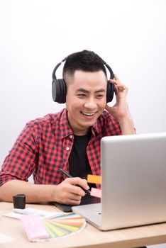 Happy designer working on his laptop in creative office