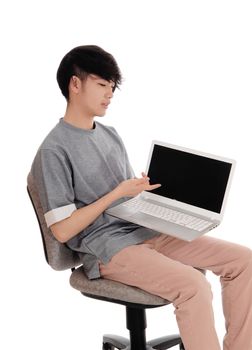 A young Korean man sitting in a gray t-shirt, holding his laptop
and pointing at the screen, isolated for white background.
