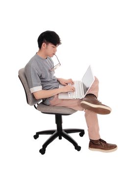 A young man sitting and working hart on his laptop to solve the
problem, with glasses, isolated for white background.
