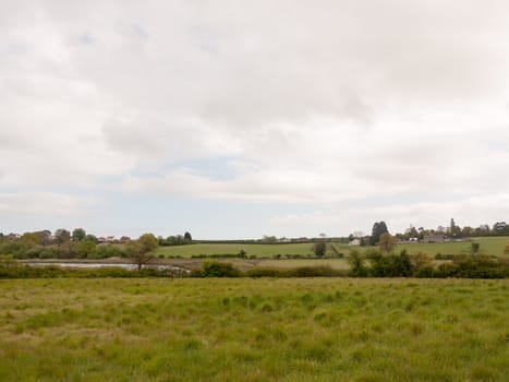 an overcast and cloudy countryside scene outside in an open field