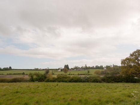 an overcast and cloudy countryside scene outside in an open field