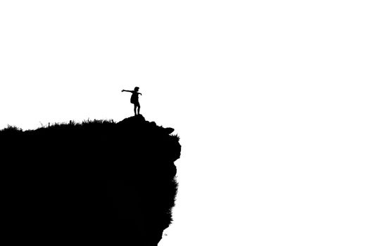 Black and white silhouette background of woman tourist standing arms outstretched happy with success on peak mountain near the cliff at Phu Chi Fa Viewpoint in Chiang Rai Province, Thailand