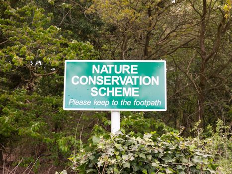 a green sign outside saying nature conservation scheme for graphic resources