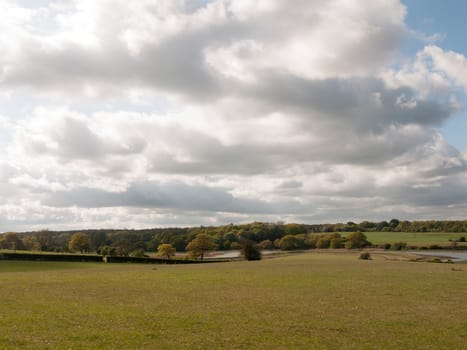 open field in the country with cloudy sky in spring