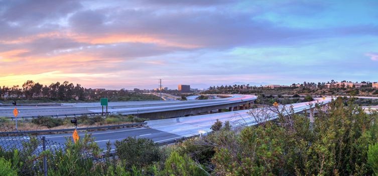 Car headlight trails at sunset traveling across a highway in Newport Beach, California