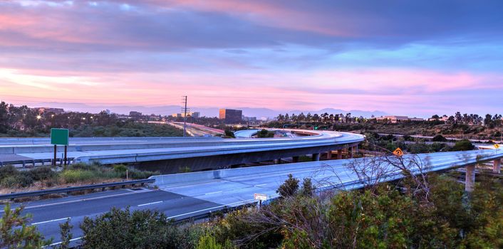 Car headlight trails at sunset traveling across a highway in Newport Beach, California