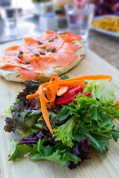 Colorful Salad with Cold Smoked Salmon on Flat Bread Closeup