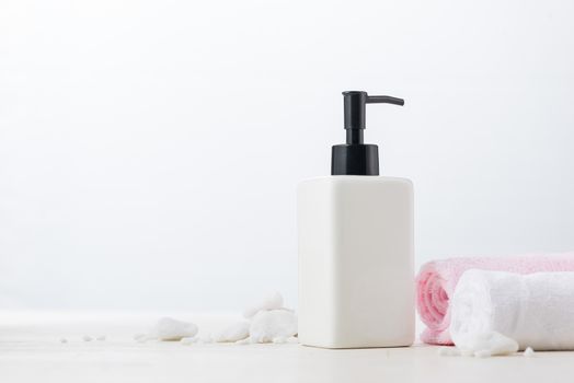 Spa composition with shampoo bottle on white.