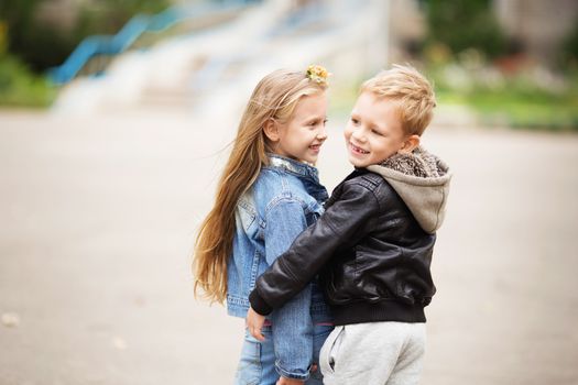 City style. Urban kids. Portrait of two happy children - boy and girl. Brother and sister hugging. School holidays concept. The first children's love