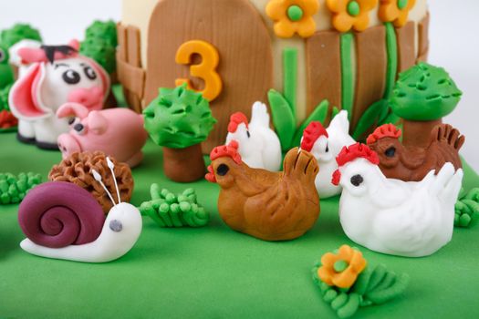 detail of birthday cake with farm marzipan animals and number 3