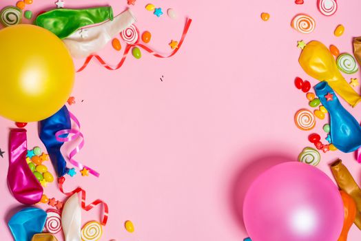 Celebration Flat lay. Candy with colorful party items on pink background.