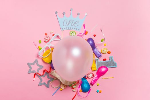 Celebration Flat lay. Candy with colorful party items on pink background.