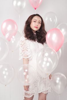 Asian pretty fashionable woman in white dress with pastel balloons