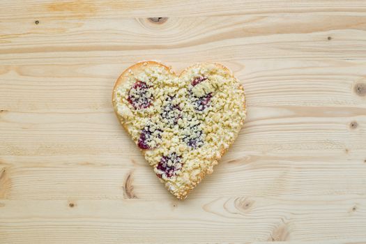 Streusel or crumble heart with jam on wood