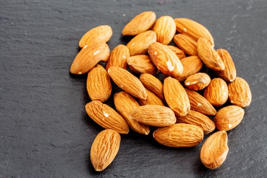 group of almonds isolated on a black slate background