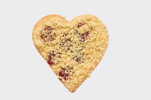 Streusel or crumble heart with jam, isolated on white