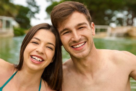 Portrait of a young couple embraced inside the pool