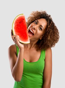 Beautiful African American woman olding and eating a watermelon fruit
