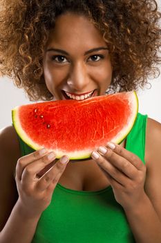 Beautiful African American woman olding and eating a watermelon fruit