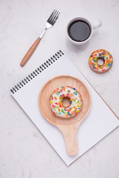 Working desk with dessert and coffee. Cake donuts with a cup of espresso on marble table top. 