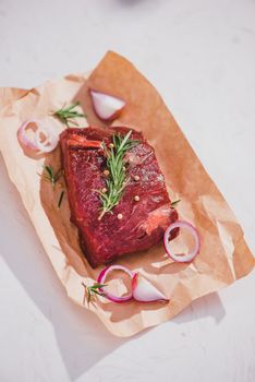 Raw beef on a cutting board  with spices and ingredients for cooking.