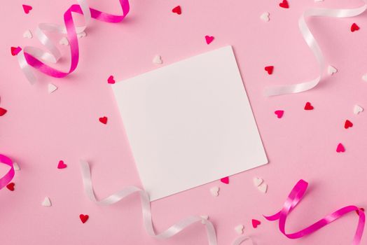 Delicate pink party background with streamers for celebrating with scattered confetti