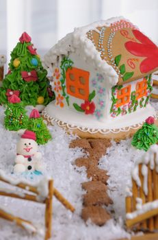Gingerbread house painted in ethnic style among the trees and snow