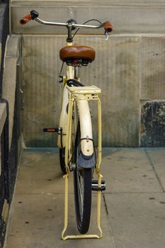 A old yellow bicycle. leather seat with shock absorbers and wheel