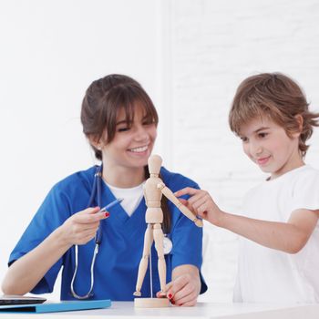 Doctor explain medicine to child using wooden doll